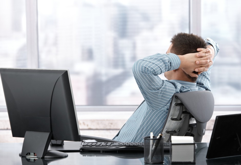 Businessman sitting in chair, resting in office.