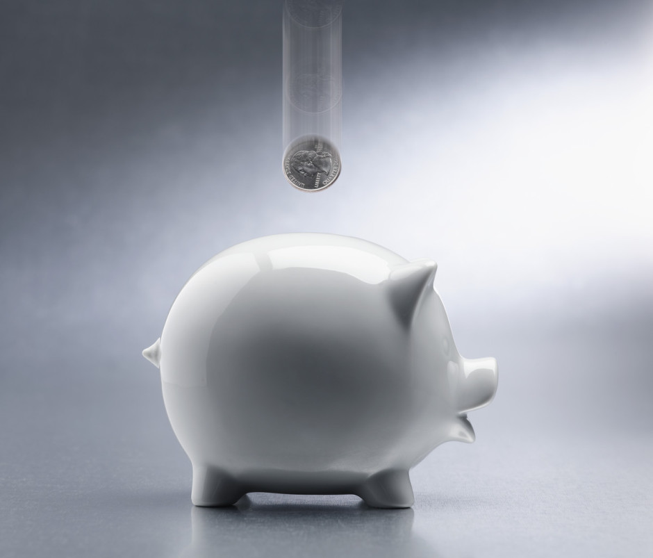 Coin Dropping Into Piggy Bank --- Image by © Royalty-Free/Corbis