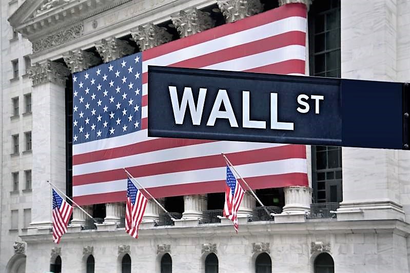 new york stock exchange with american flags and wall street sign in front