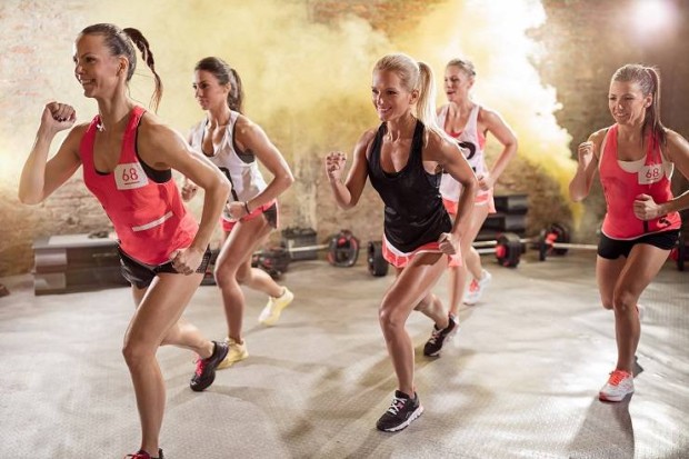 Group of young women in running pose, high-energy fitness class