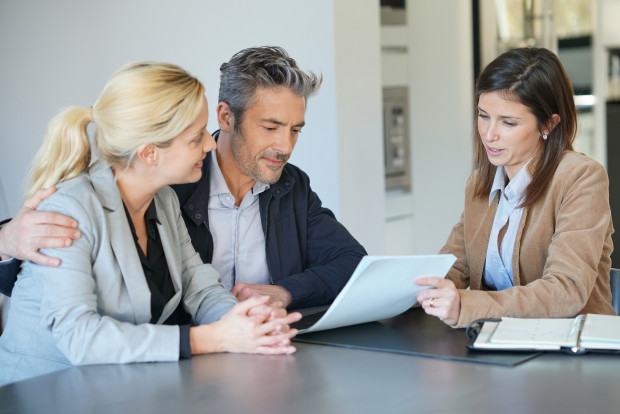 Real-estate agent reading terms of contract to clients