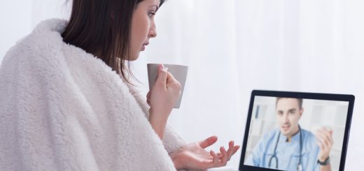 Przeziębiona młoda kobieta w trakcie videokonsultacji z lekarzem.